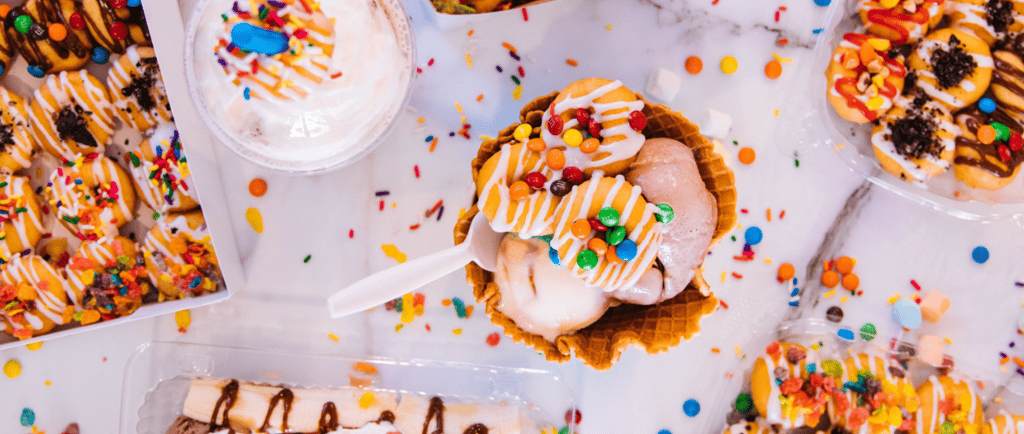 a table with desserts and sweets ice cream, cookies and smarties