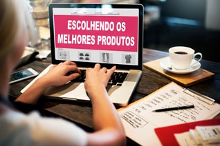 a person sitting at a table with a laptop and a cup of coffee