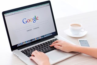a person sitting at a desk with a laptop and a cup of coffee