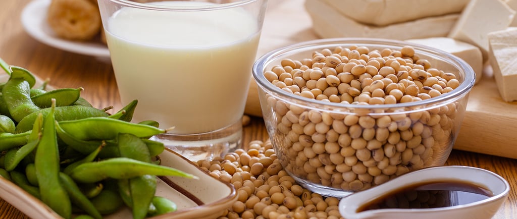 a table with a glass of soy milk and a bowl of soy beans