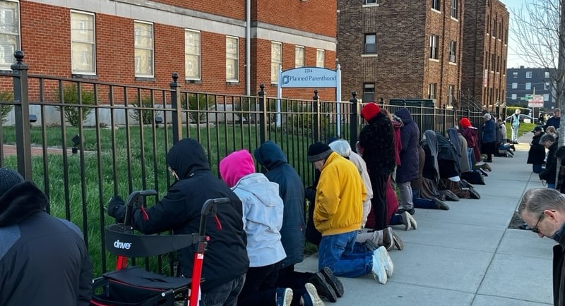 A group of people peacefully praying in front of planned parenthood