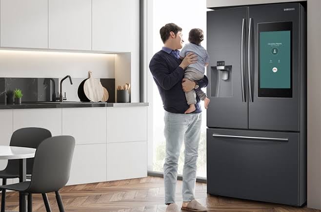 homem e seu filho olhando para uma geladeira inverter