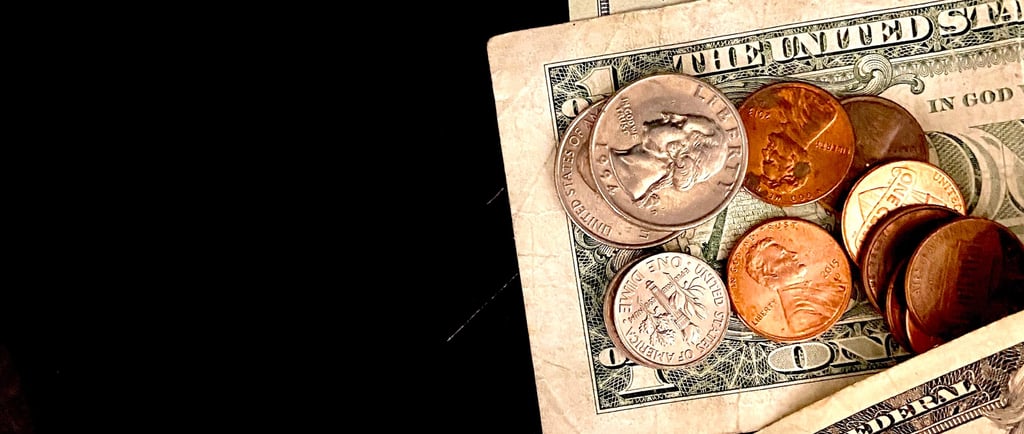 a pile of coins and a dollar bill