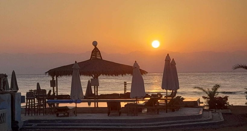 Vue du lever du soleil depuis la piscine avec vue sur la mer en Égypte