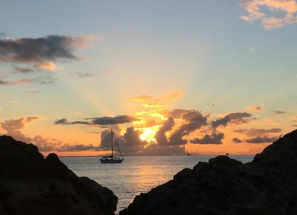 sunset with rays of light and yacht in the sea