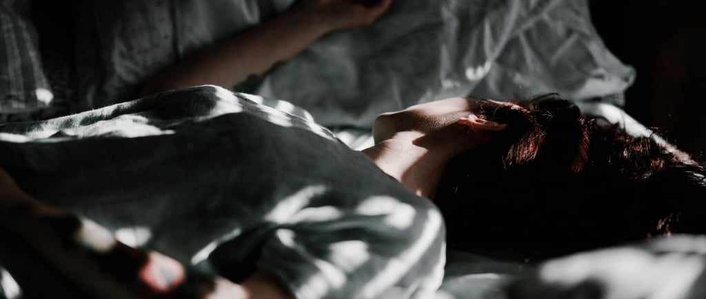 moteris guli lovoje, pasidėjusi galvą ant pagalvės