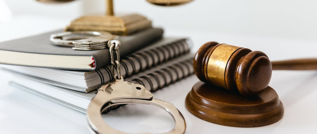 handcuffs on judge desk with notebooks and gavel