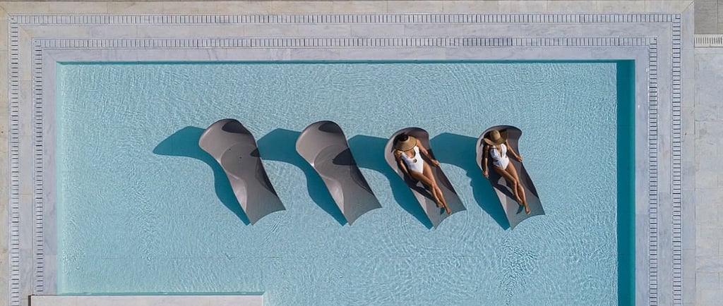 a couple of people sitting in a pool in mykonos