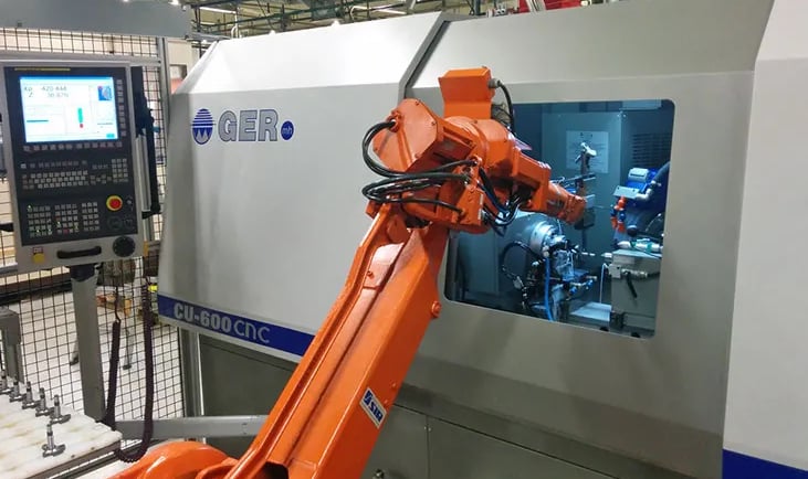 Robot en proceso de craga de pieza a torno CNC