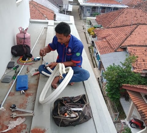 seorang teknisi sedang service sekalian pasang ac di rumah sentul city bogor