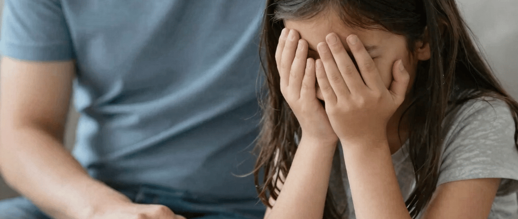 parent assis près d'un enfant triste
