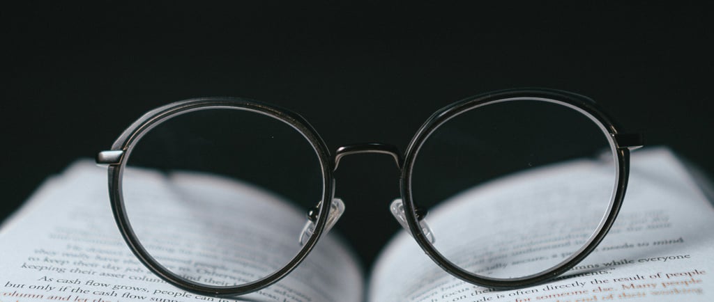 Um óculos preto sobre um livro aberto