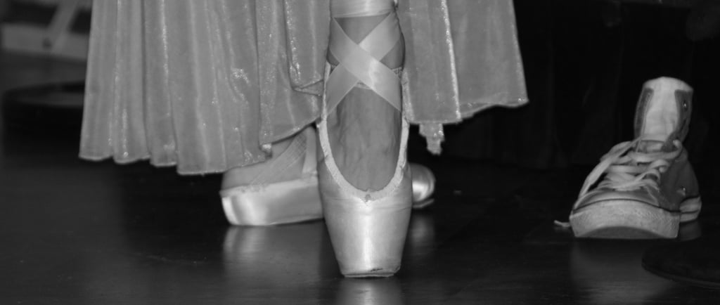 Ballerina Schuhe bei Spitzentanz, daneben ein Sportschuh