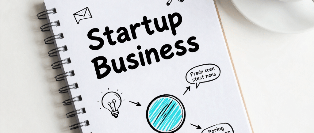 A clean white desk with a minimalist notebook open to a business roadmap sketch, a cup of coffee nea