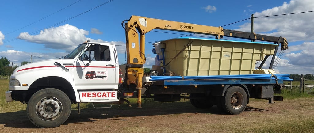 A truck with a large container on it, equipped with a telescopic boom truck mounted crane.