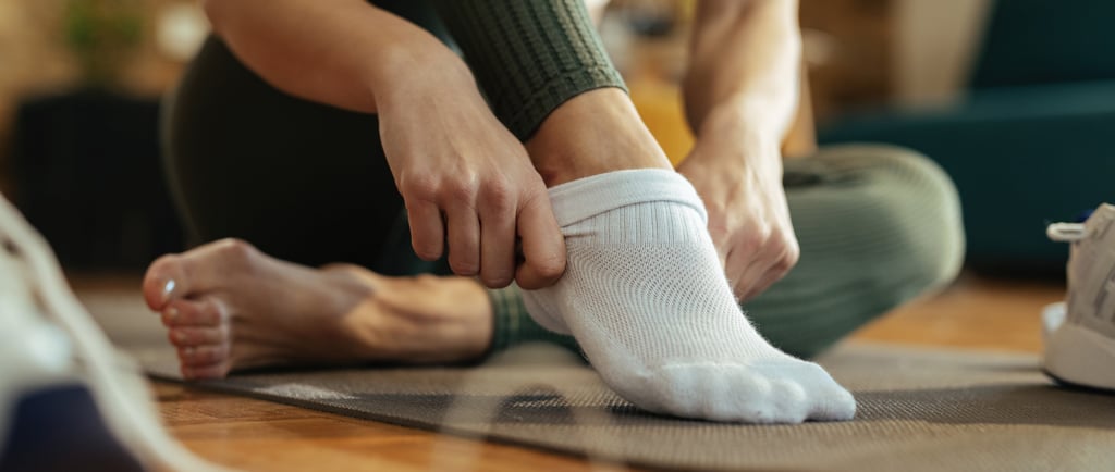 person putting on pilates grip socks 