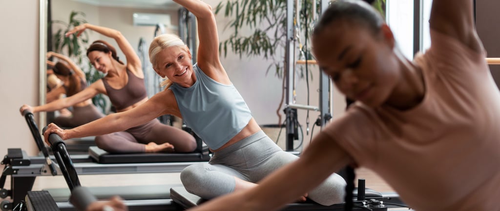 a woman is doing reformer pilates in a group fitness class