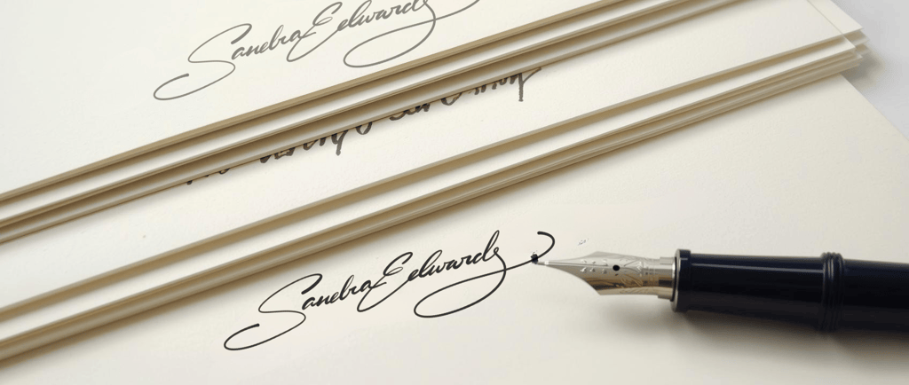 Elegant handwritten signature on ivory stationery paper with a luxury fountain pen.