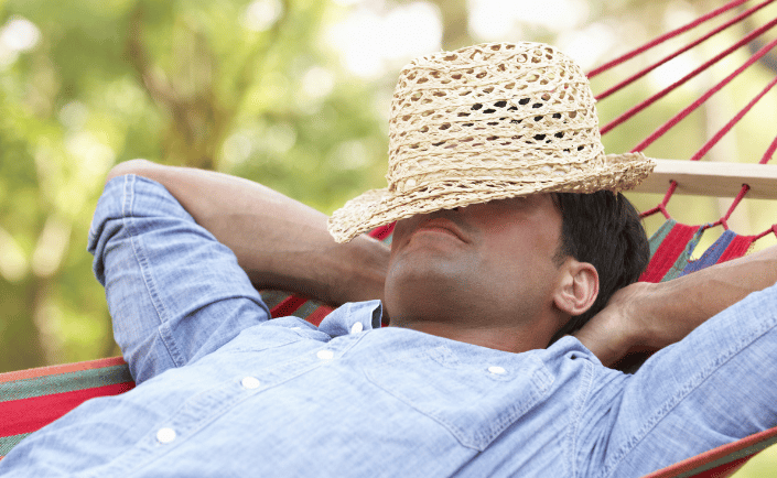 a man in a straw hat is laying in a hammock