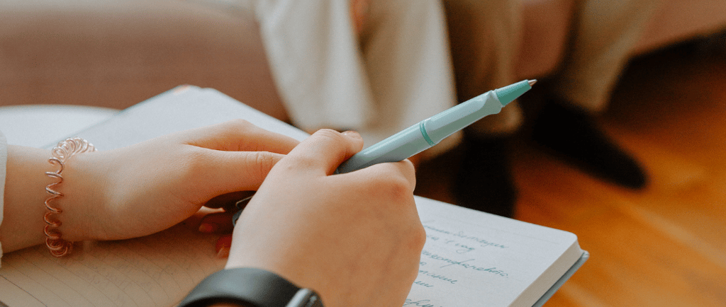 a person sitting on a couch with a pen and a pen