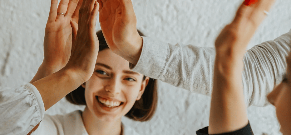 a woman is giving a high five finger sign