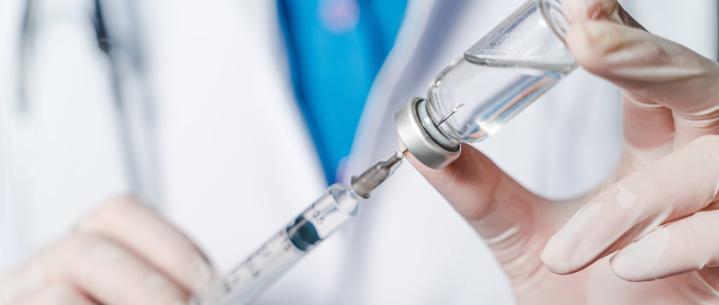 Healthcare professional dispensing medication via needle and syringe.