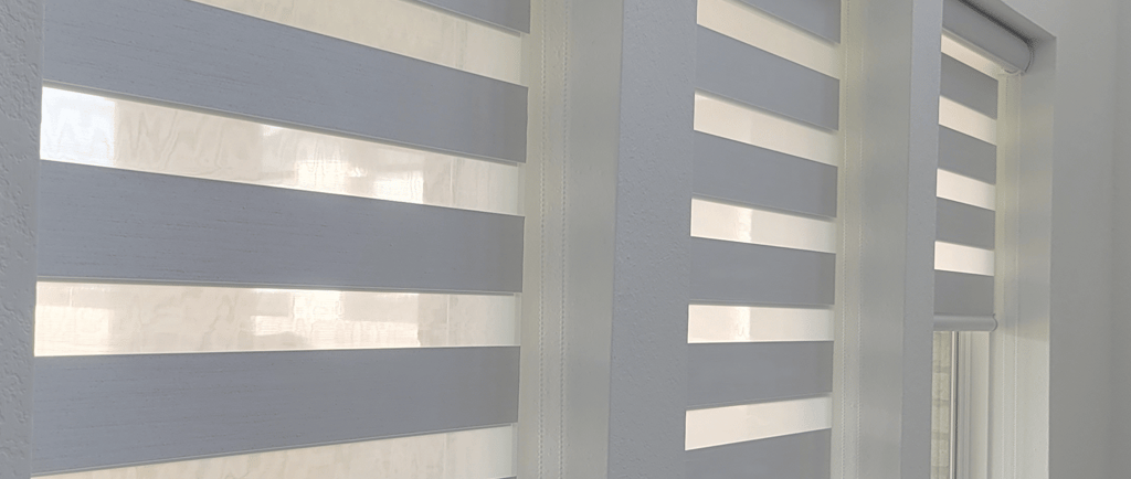 a bedroom with a bed and a window with blinds