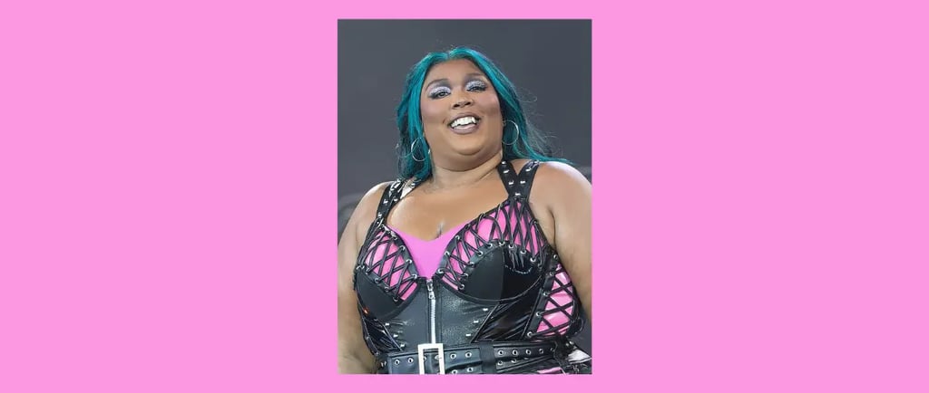 Lizzo singing on stage, wearing a black and pink outfit.