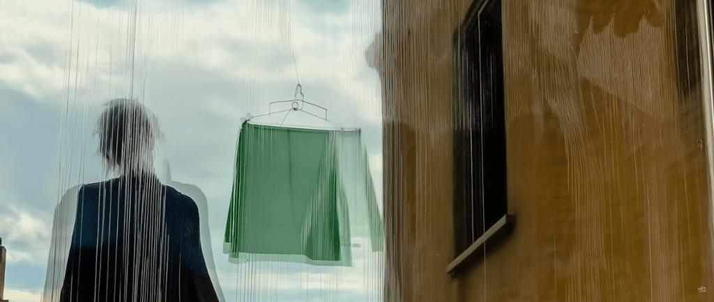 a figure in front of a building and a washing line