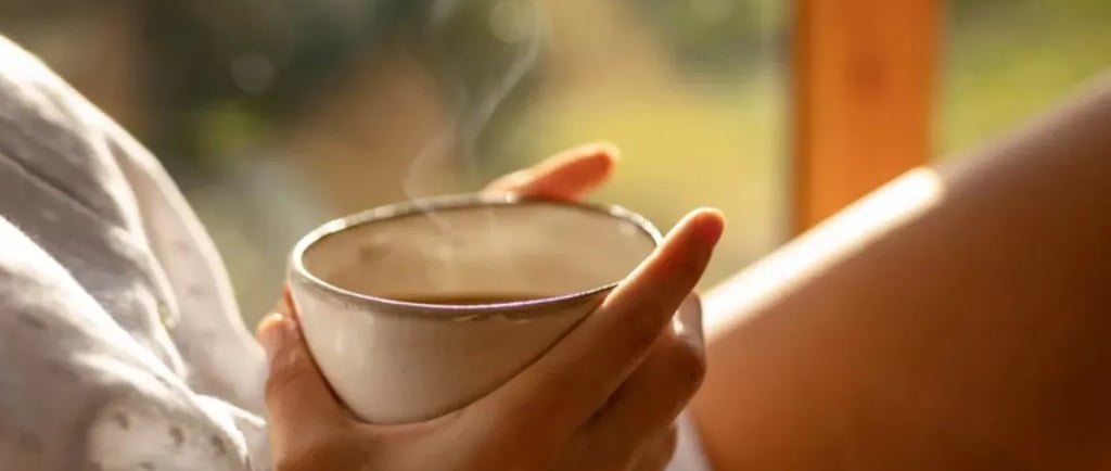 uma mulher segurando um copo de café na mão