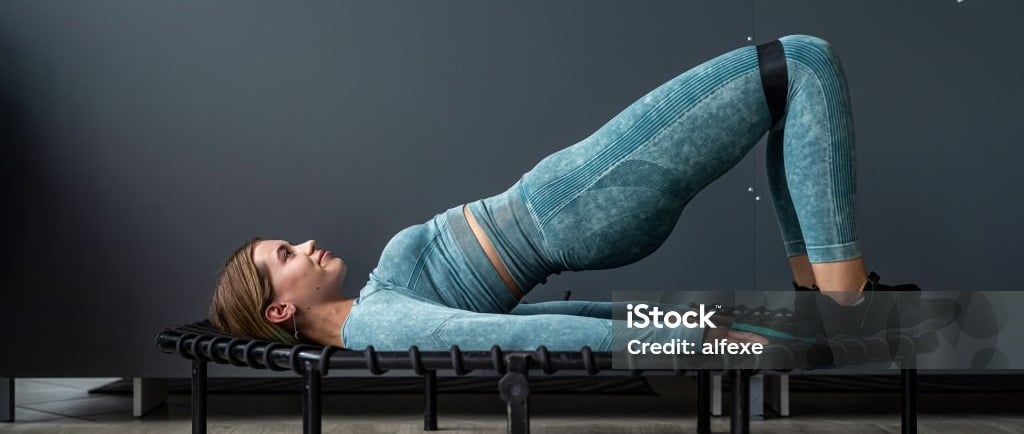 a woman doing a yoga pose on a bench
