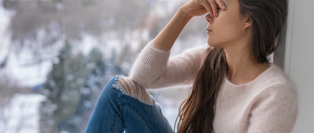 mulher sentada, com a mão no rosto, demonstrando tristeza