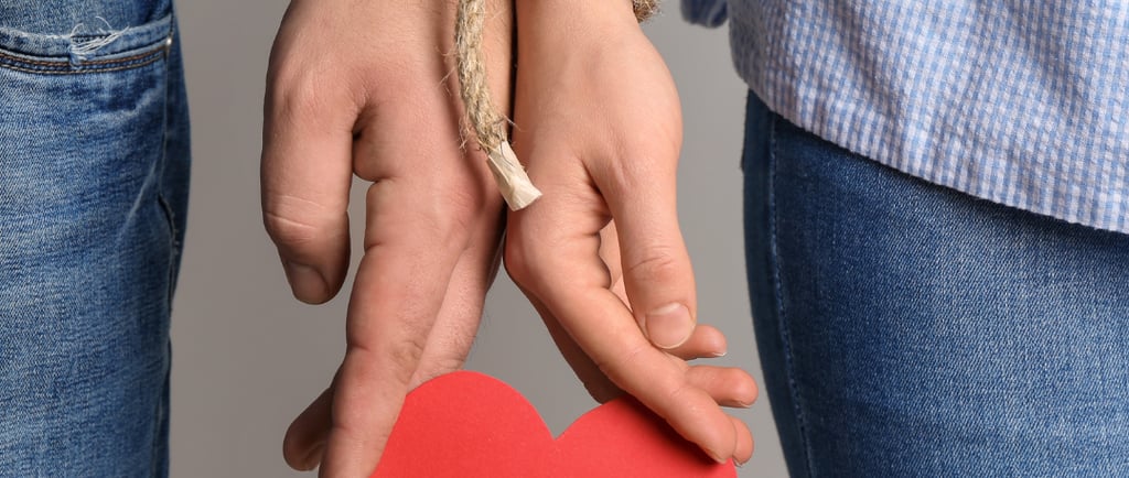 a mão de um homem e a mão de uma mulher estao amarradas segurando um coração