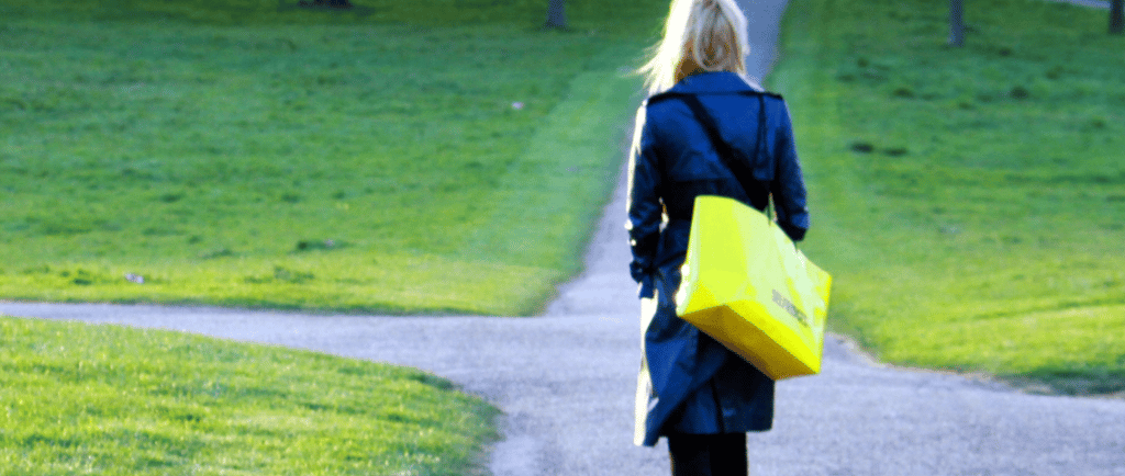 uma mulher caminhando por uma pequena estrada, meio quem sem rumo