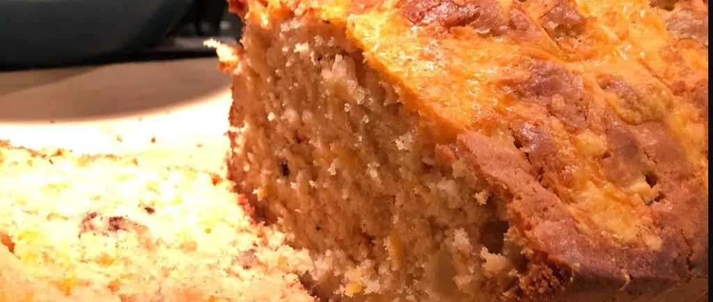 apple cheddar bread with one slice on cutting board