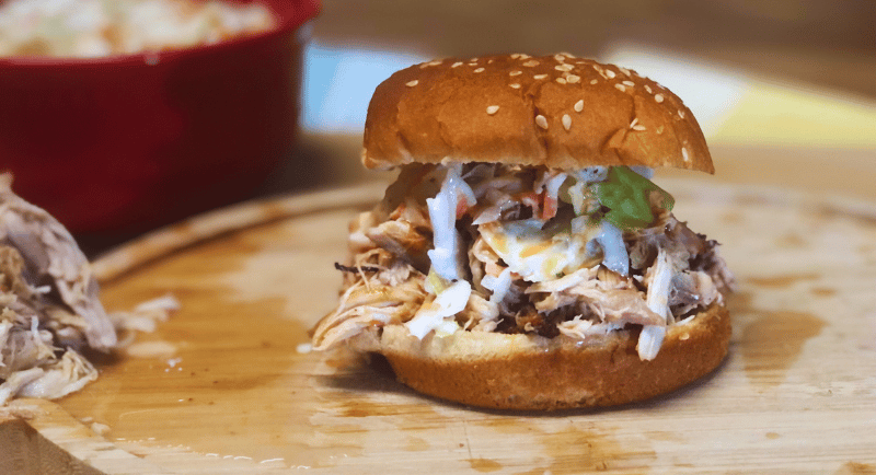 Carolina pulled chicken with coleslaw and hotsauce on a cutting board