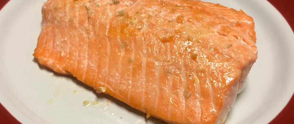 buttery lemon garlic steelhead trout on a white and red plate