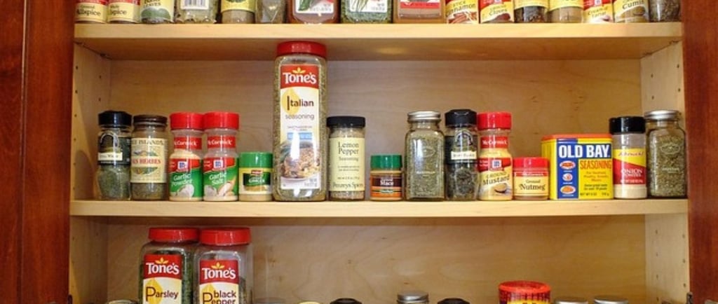a large variety of spices in the kitchen cabinet.