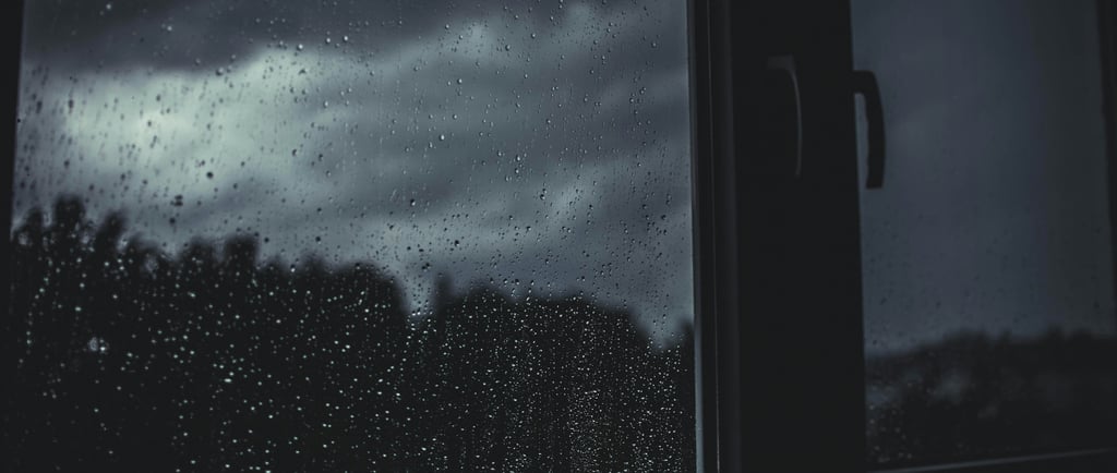 View of dark storm clouds through a window during a summer thunderstorm