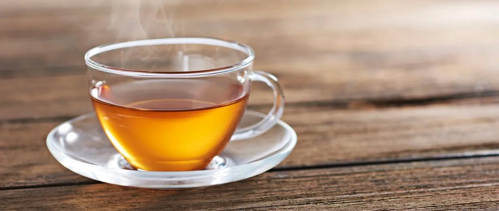 A warm cup of tea sitting on a wooden table, capturing the feeling of a quiet moment shared at home