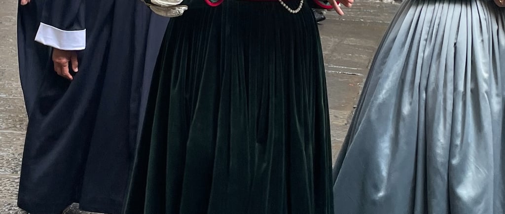 3 people in medieval dress in a procession