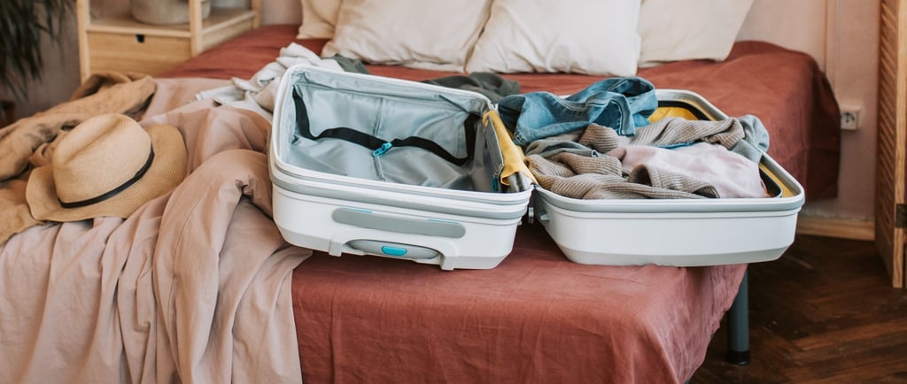 Valigia aperta sul letto con vestiti pronti, per la checklist prima di partire da soli dopo i 60 ann