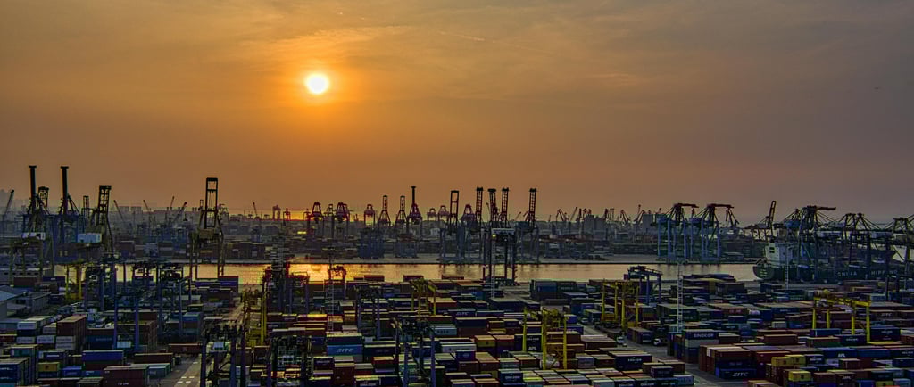 a large amount of containers of containers sit in a harbor