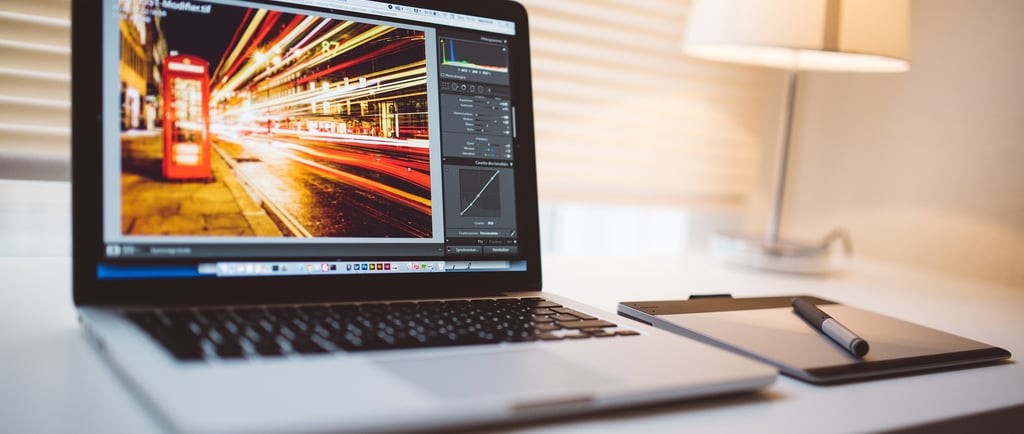 open laptop sitting on a white desk with the laptop screen showing sped up traffic and light