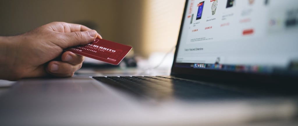 A hand holding a credit card about to make a purchase