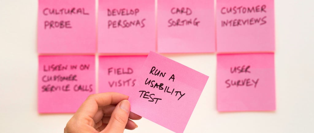 A hand holding a pink sticky note
