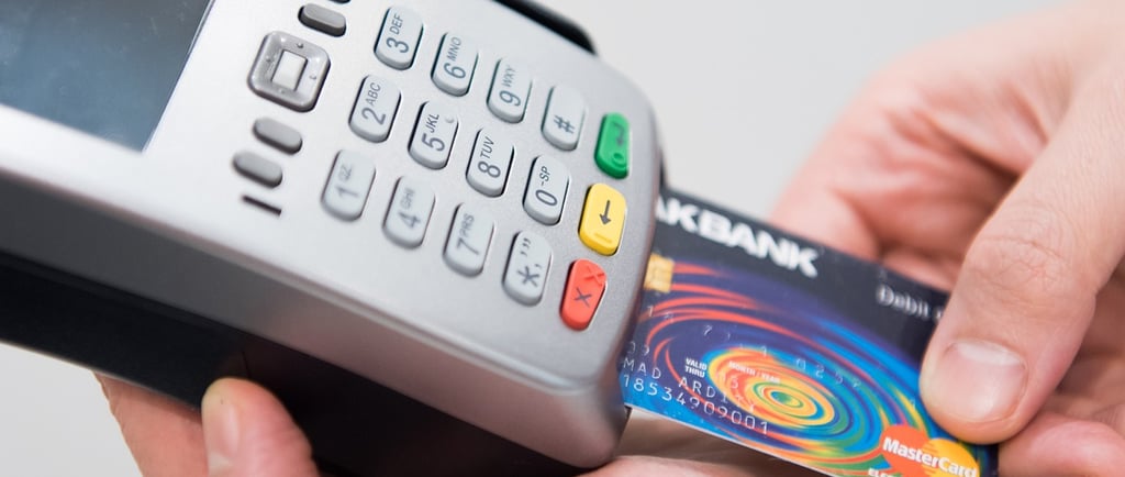 a person holding a credit card and a credit card