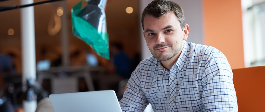 a man sitting at a desk with a laptop computer