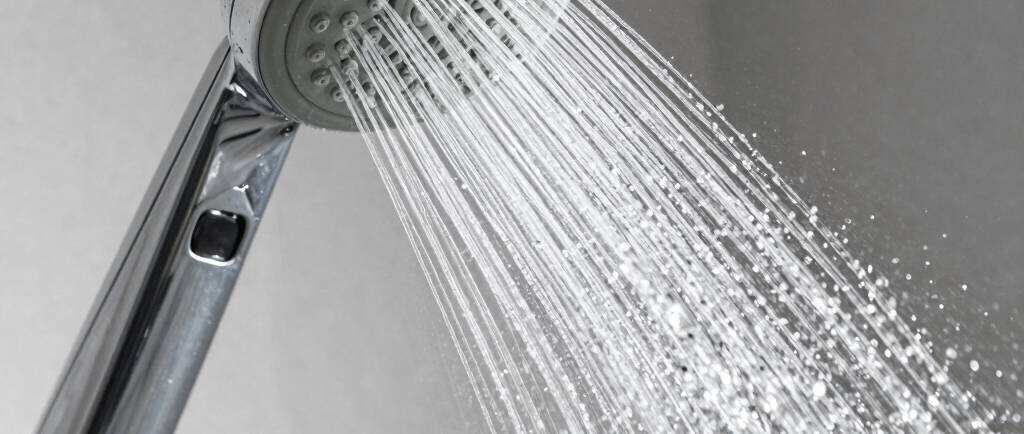 a close up of a shower head with water coming out of it