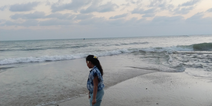 a woman standing on a beach with a kite kite